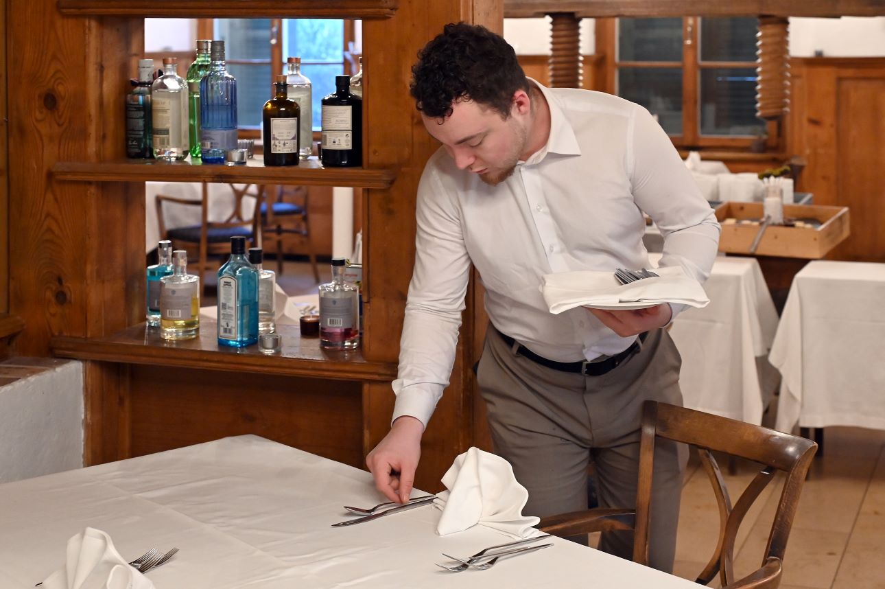 Mitarbeiter deckt den Tisch im Gasthof Liebefeld.